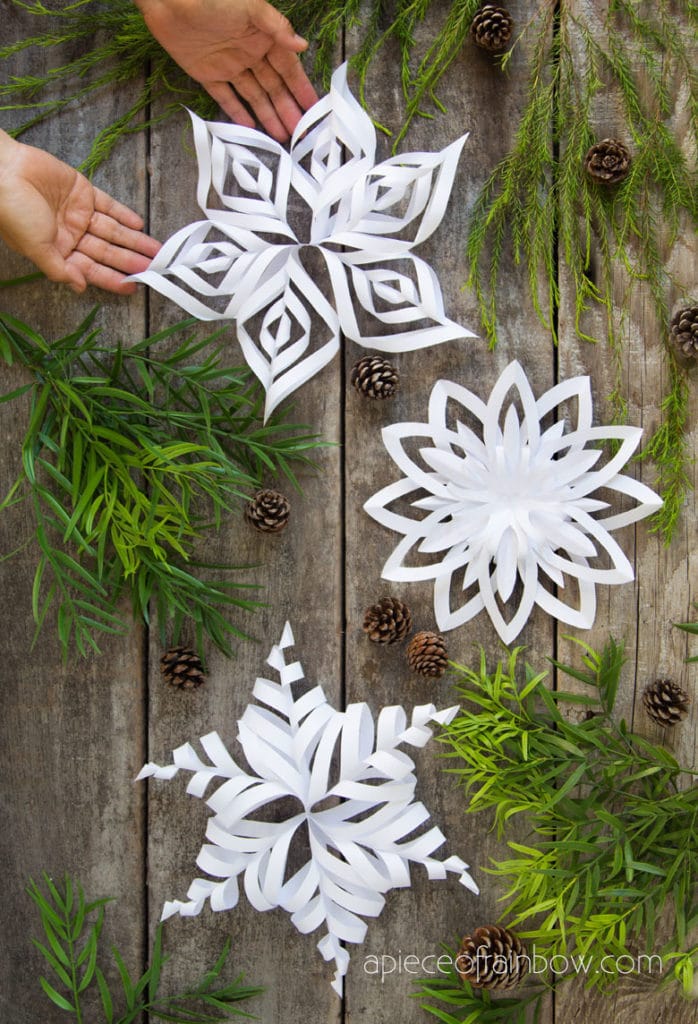 Intricate Paper Snowflakes Arranged with Pinecones