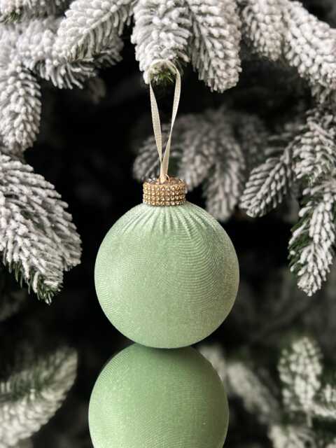 Modern Close-Up of a Sage Green Velvet Ornament on a Flocked Tree Modern Close-Up of a Sage Green Velvet Ornament on a Flocked Tree — Sage Green Christmas Decor