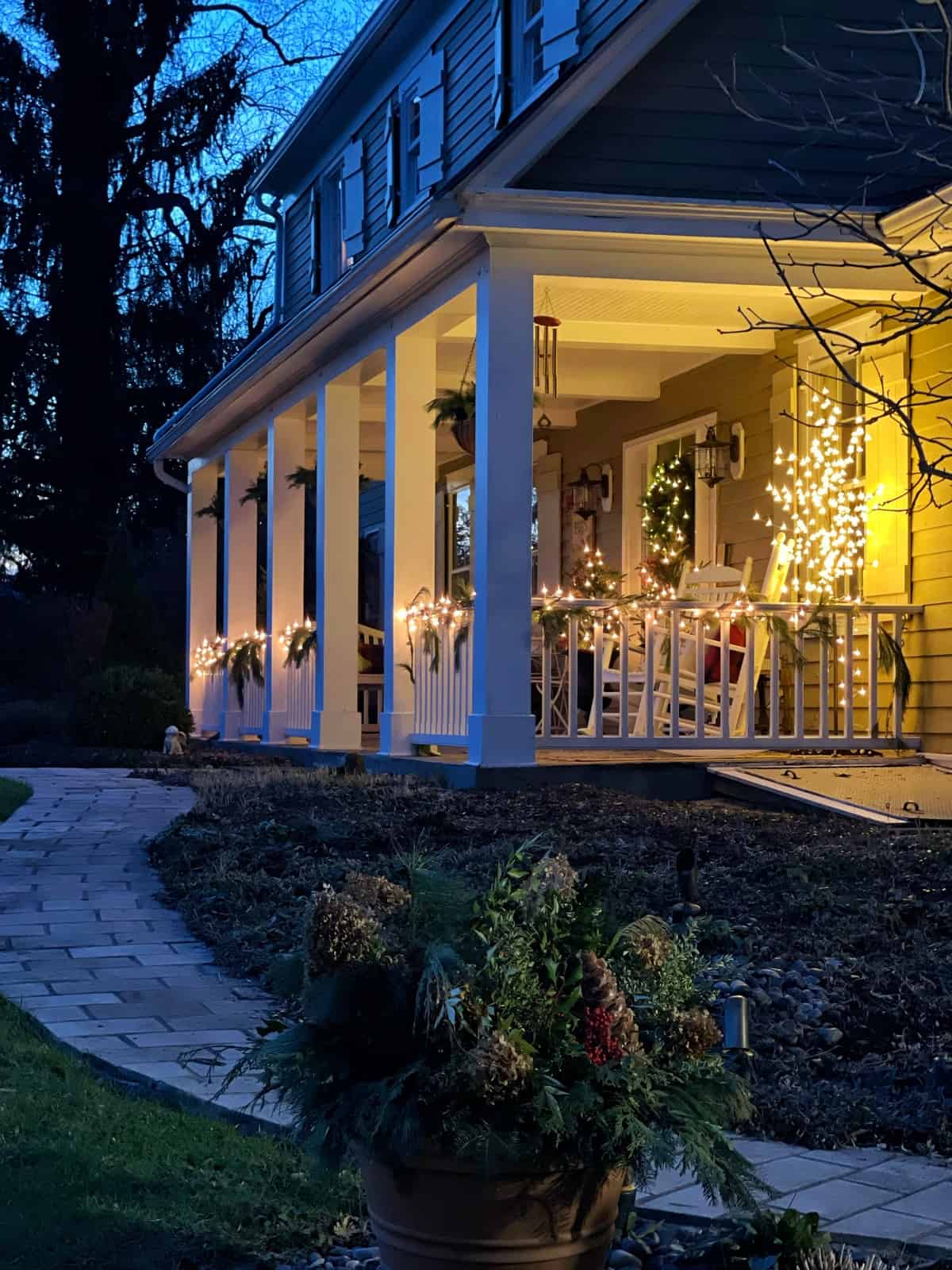 Long Farmhouse Porch Bathed in Warm String Light Glow at Dusk — Farmhouse Christmas Porch