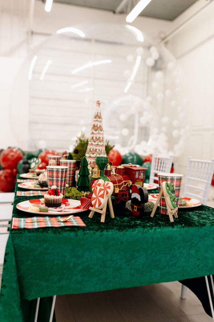 Playful Party Table with Green Velvet, Plaid, and a Christmas Train Centerpiece — Christmas Party Decor