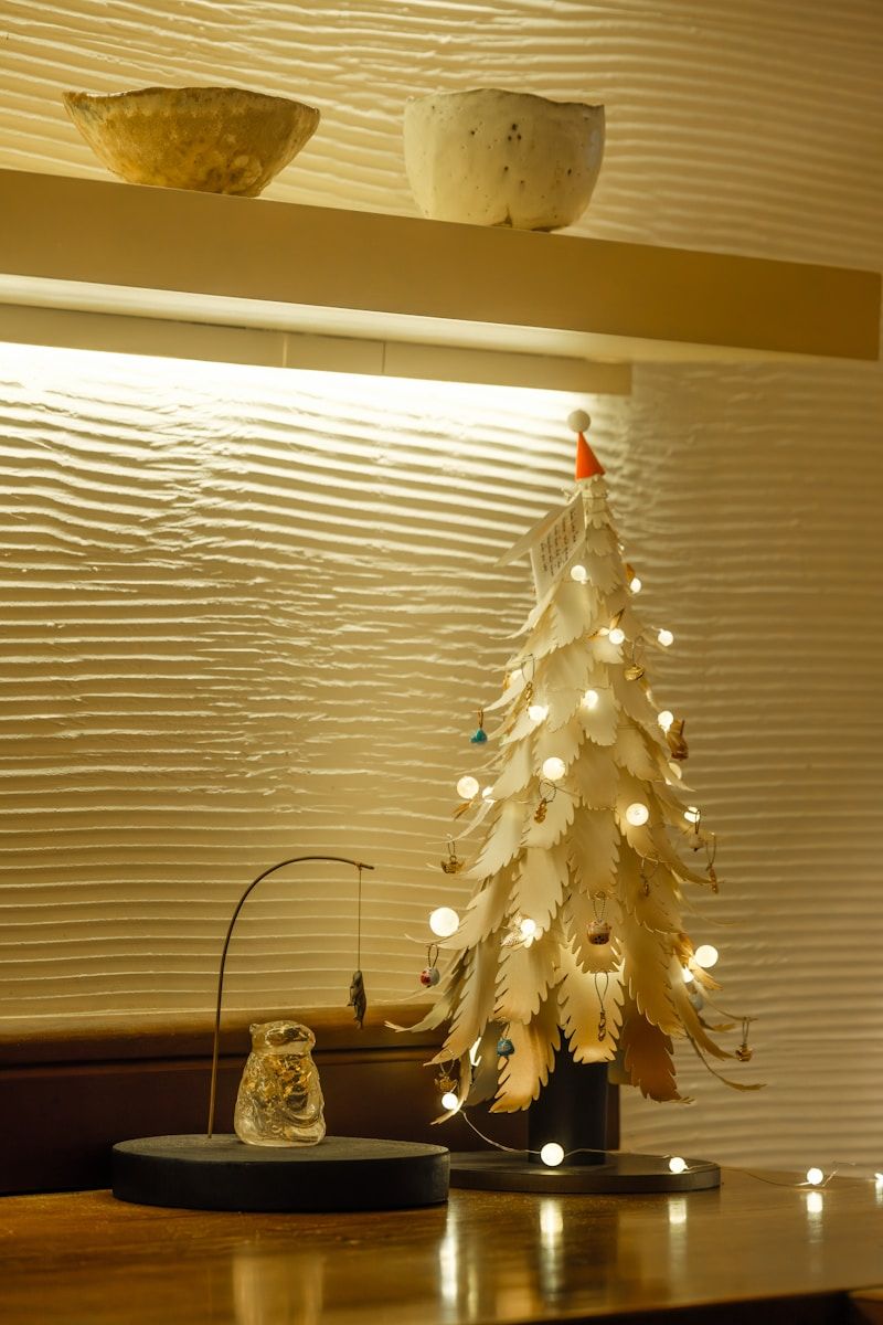 Ornate Miniature Christmas Tree on a Wooden Desk — Christmas Office Decor Ideas