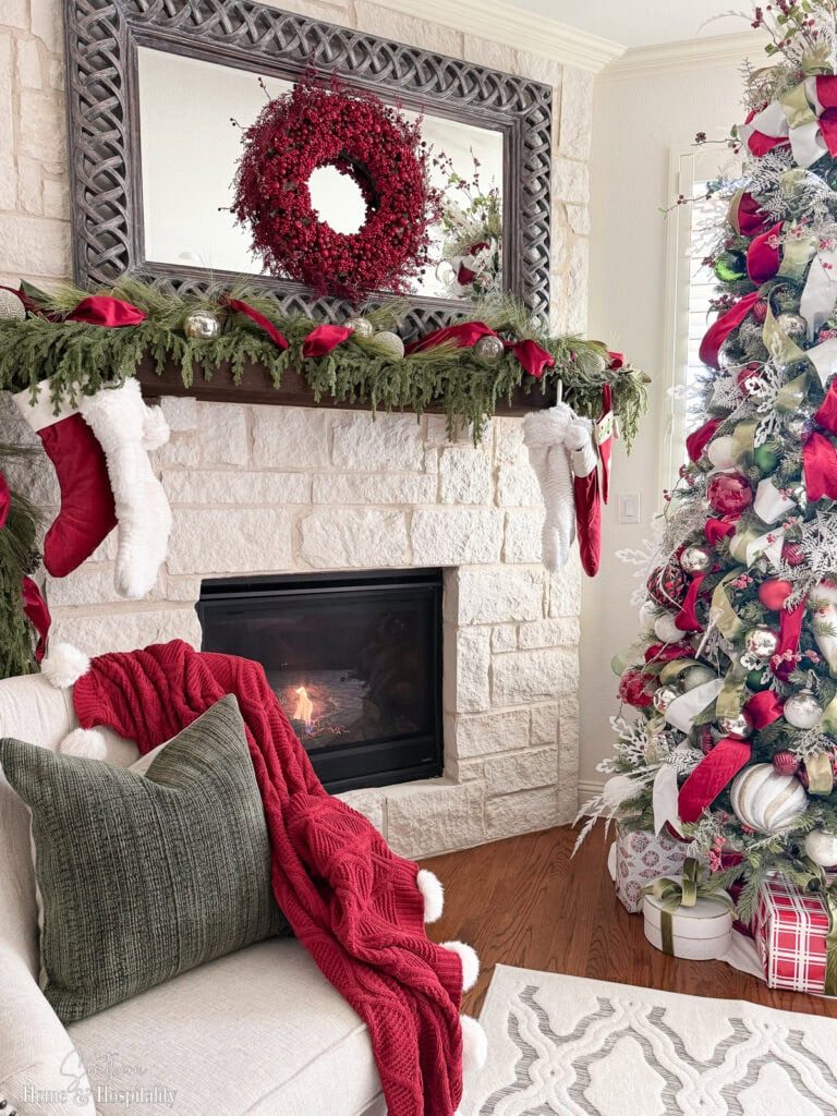 Modern Farmhouse Fireplace with Red Knitted Throw and Greenery Garland Modern Farmhouse Fireplace with Red Knitted Throw and Greenery Garland — Christmas Fireplace Decor