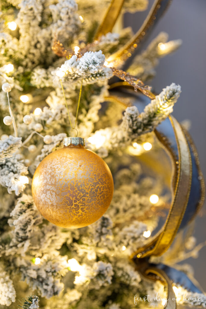 Elegant Detail: Textured Gold Ornament on Flocked Branch Elegant Detail: Textured Gold Ornament on Flocked Branch — Flocked Christmas Tree Decor
