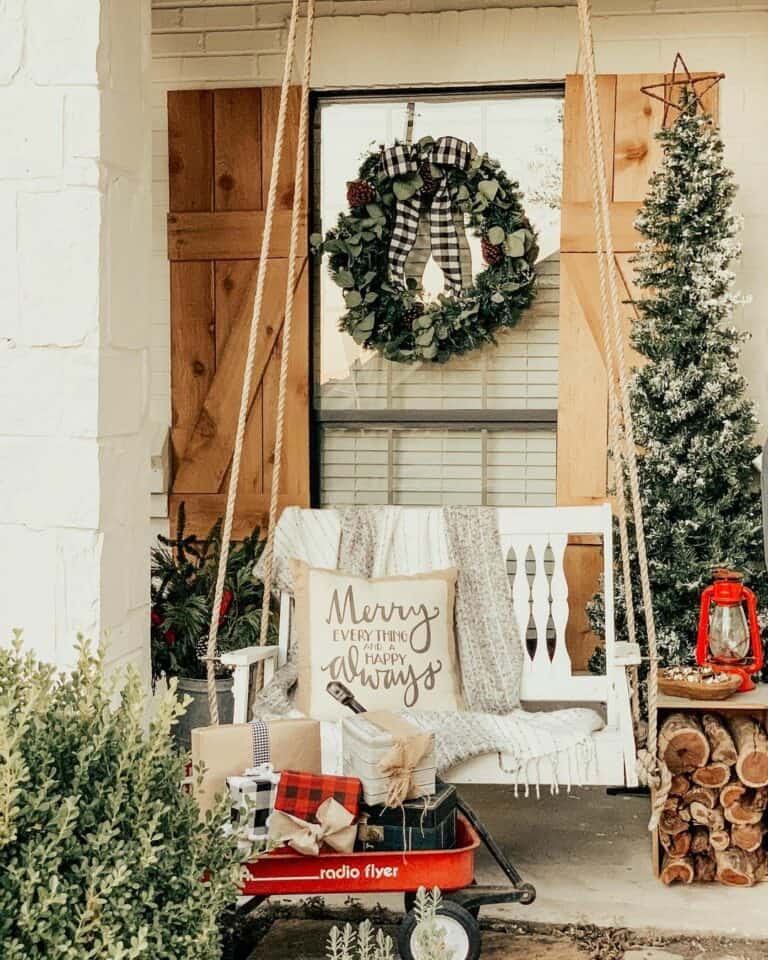 Cozy Porch Swing Bench with Festive Pillows and a Red Wagon — Farmhouse Christmas Porch