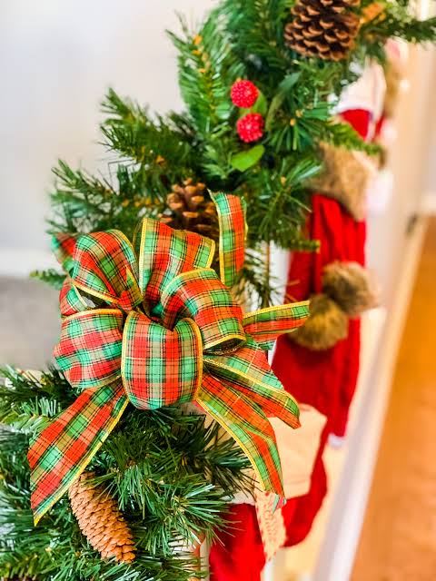Festive Pine Garland with Red and Gold Plaid Bow on Mantel — Christmas Decor