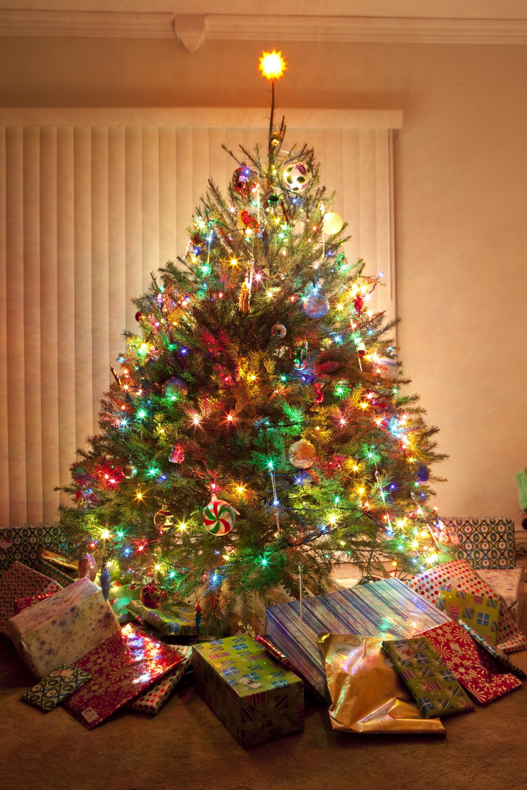 Centerpiece Tree with Abundant Multicolor Lights and Scattered Gifts Centerpiece Tree with Abundant Multicolor Lights and Scattered Gifts — Christmas Tree with Colored Lights