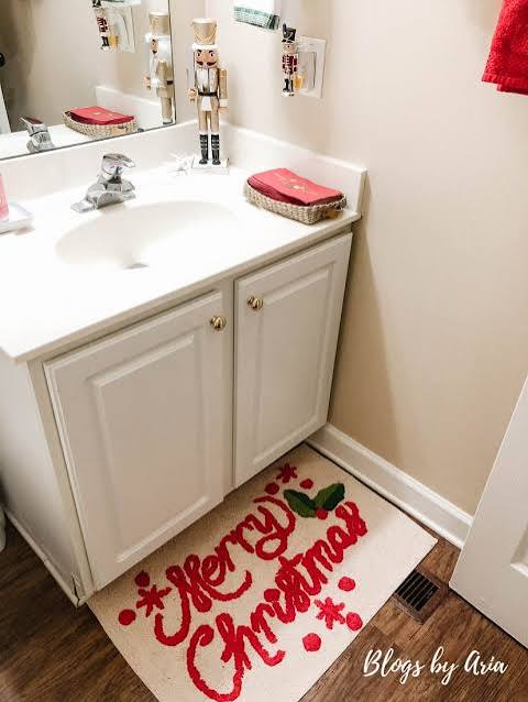 Traditional Vanity with Nutcracker Figures and Festive 'Merry Christmas' Rug Traditional Vanity with Nutcracker Figures and Festive 'Merry Christmas' Rug — Christmas Bathroom Decor
