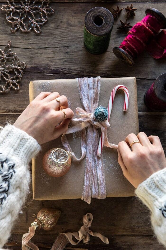 Cozy Knit Sweater Hands Tying Velvet Ribbon with Candy Cane Detail — Christmas Gift Wrapping