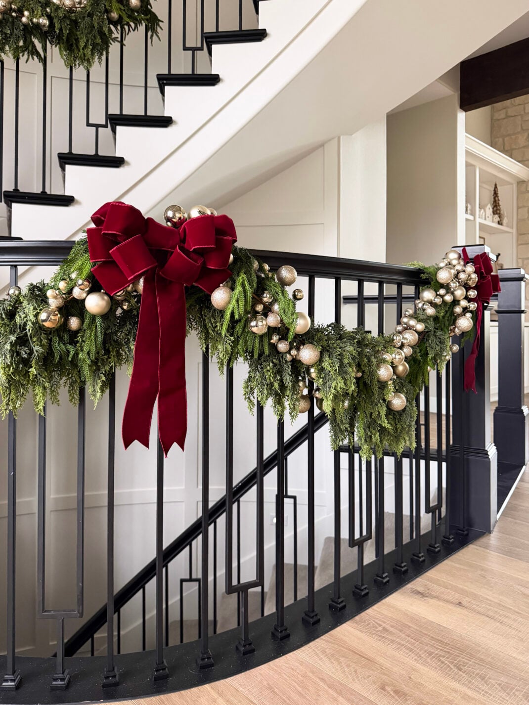 Festive Garland with Burgundy Velvet Bows on a Staircase Banister — Burgundy Christmas Decor