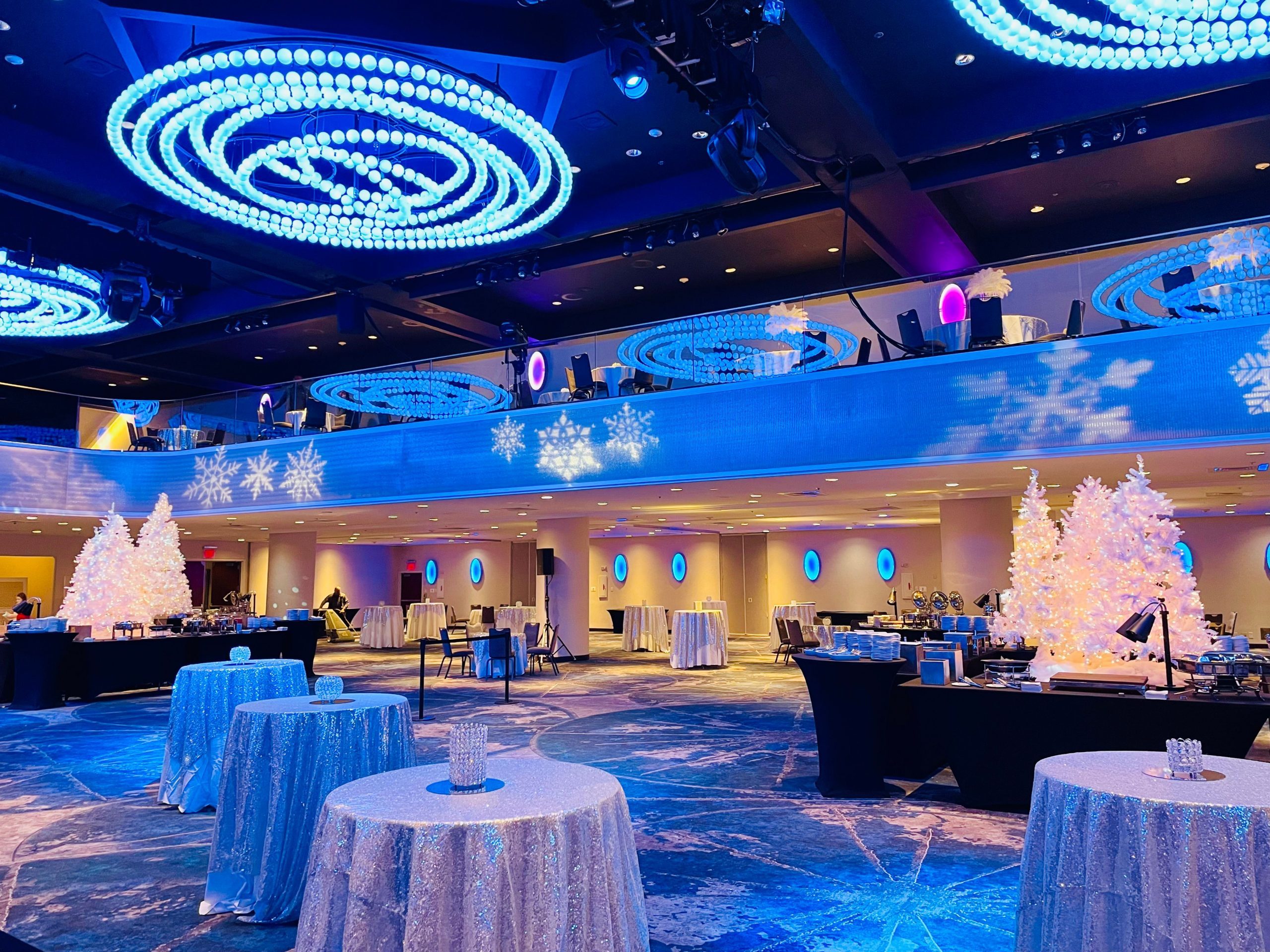 Modern Event Space with Blue and White Lighting and Sequined Tables — Christmas Party Decor