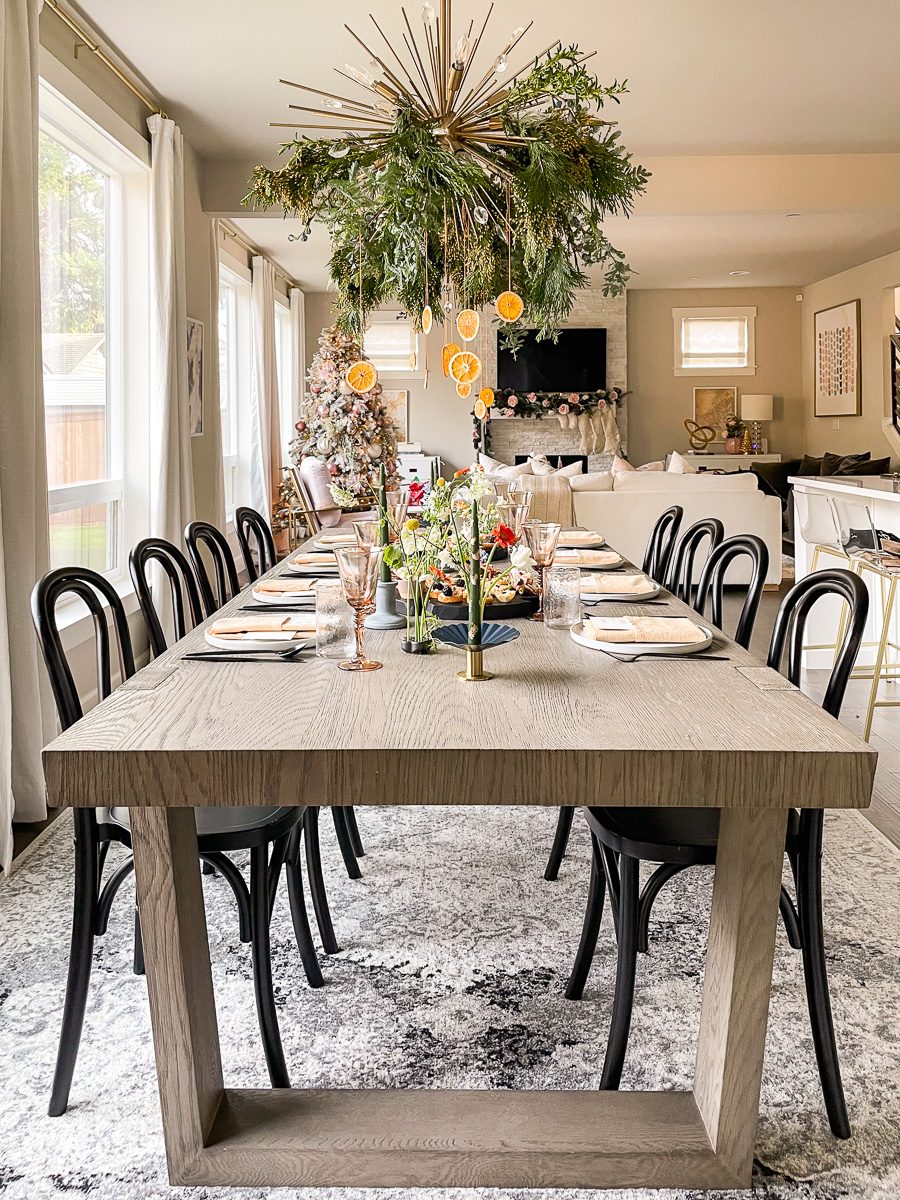 Modern Dining Room with Overhead Greenery Installation and Dried Oranges — Modern Christmas Decor