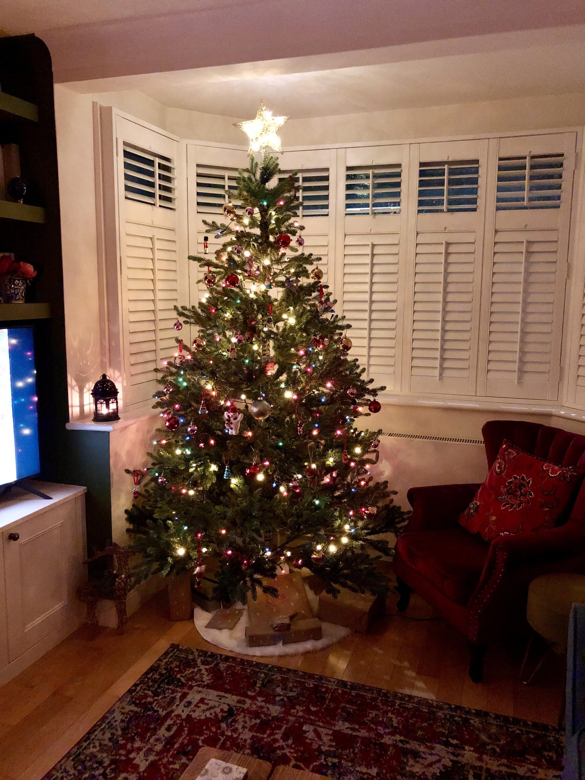 Cozy Living Room Corner with Multicolor Lights and Red Armchair Cozy Living Room Corner with Multicolor Lights and Red Armchair — Christmas Tree with Colored Lights