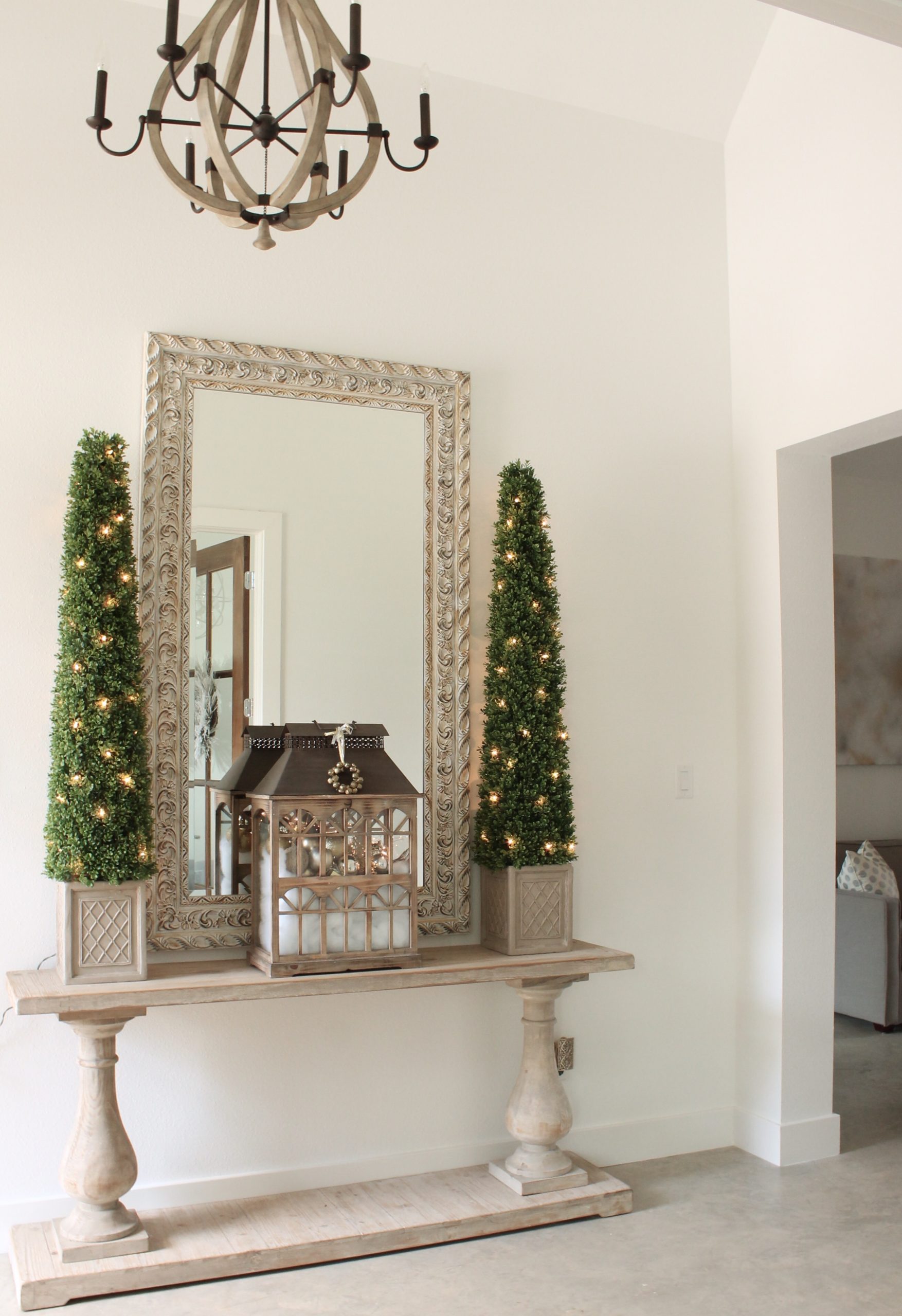 Farmhouse Entryway Console with Ornate Mirror and Lit Trees Farmhouse Entryway Console with Ornate Mirror and Lit Trees — Christmas Entryway Decor