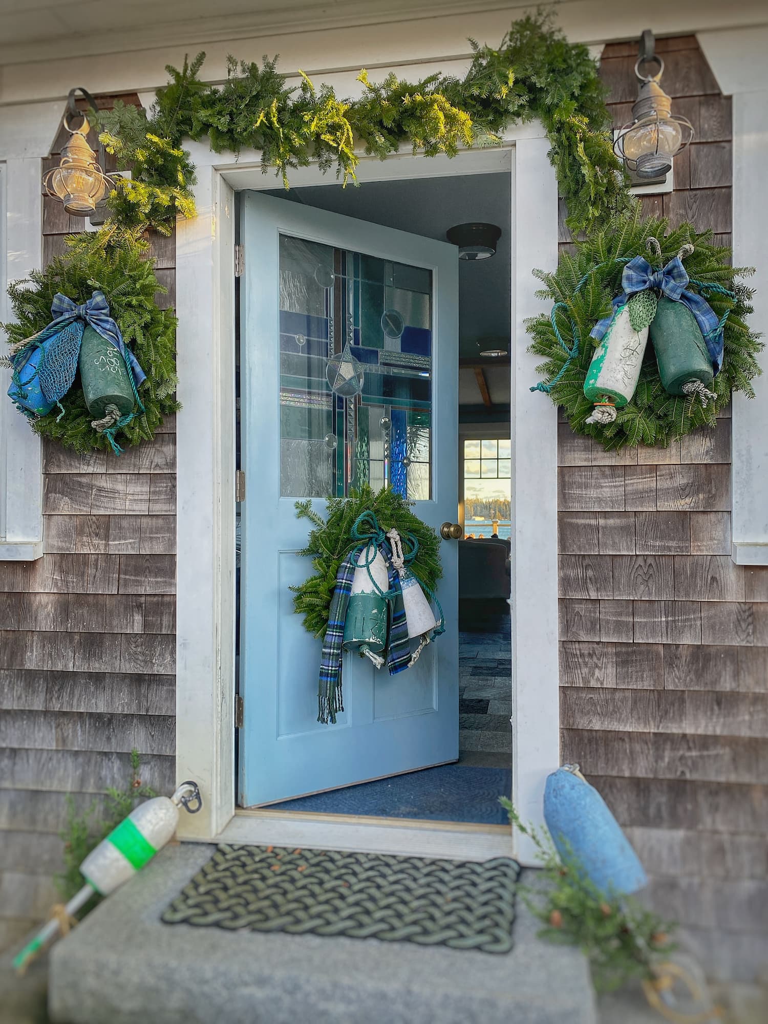 Coastal Entryway with Buoy Wreaths on Blue Door Coastal Entryway with Buoy Wreaths on Blue Door — Coastal Christmas Decor