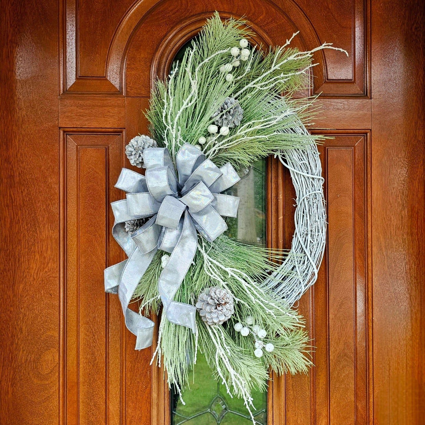 Rustic Christmas Wreath with Frosted Pine and a Silver Bow on a Wooden Door Rustic Christmas Wreath with Frosted Pine and a Silver Bow on a Wooden Door — White Christmas Decor