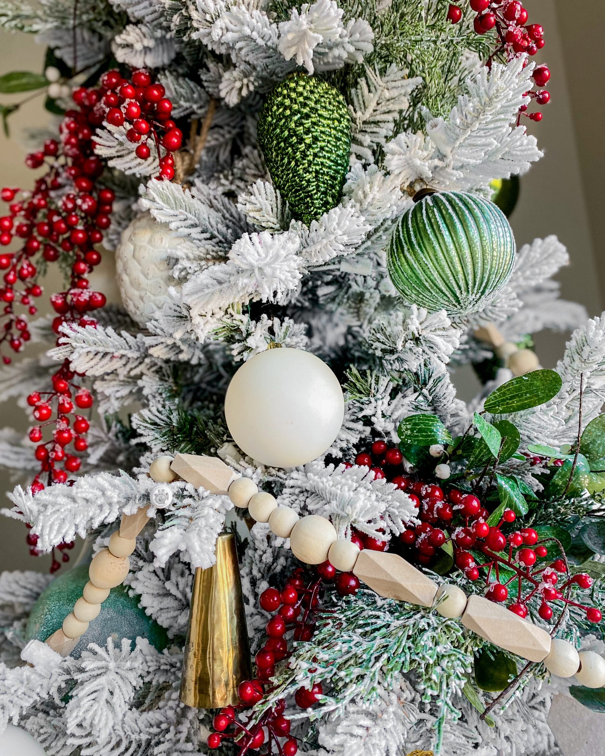 Close-Up of Flocked Tree with White Ornaments and Red Berries — White Christmas Tree Decor