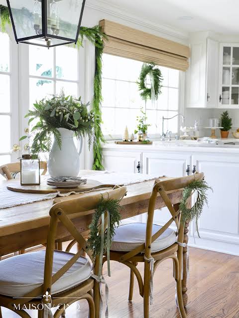 Modern Farmhouse Dining Area with Greenery on Chairs and Eucalyptus — Christmas Kitchen Decor