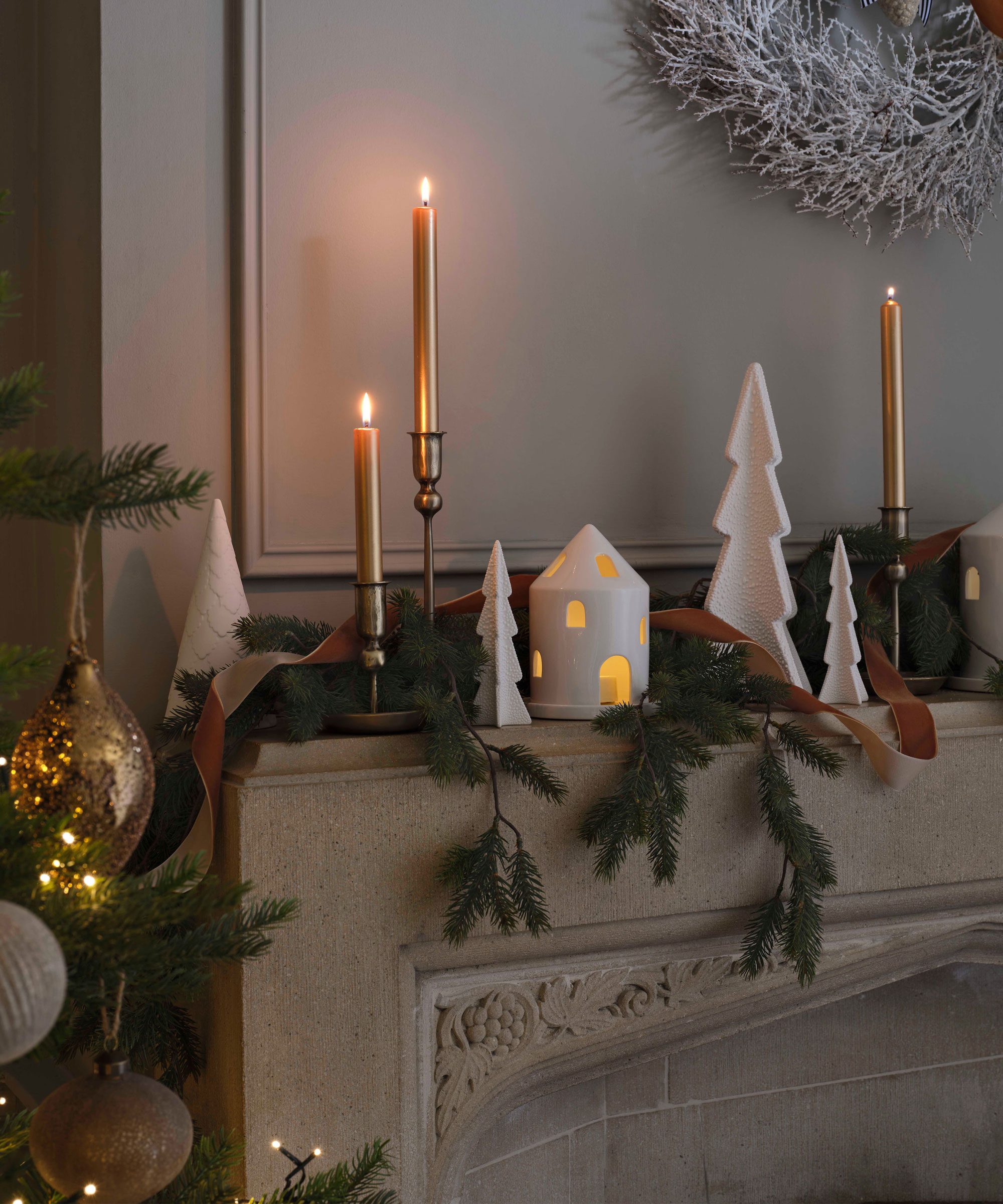 Festive Fireplace Mantle with Gold Taper Candles and Ceramic Houses — Christmas Candle Decor