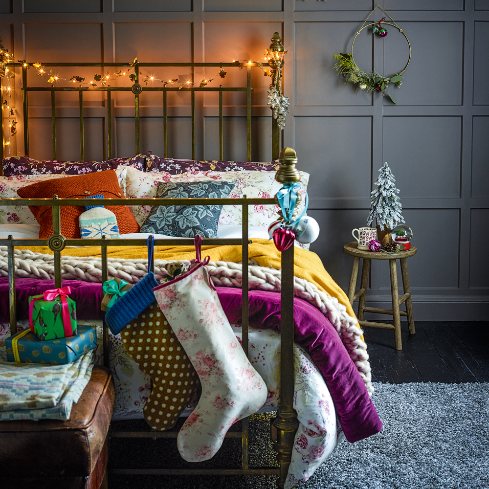 Brass Headboard Draped with Fairy Lights and Festive Stockings — Christmas Fairy Lights Headboard