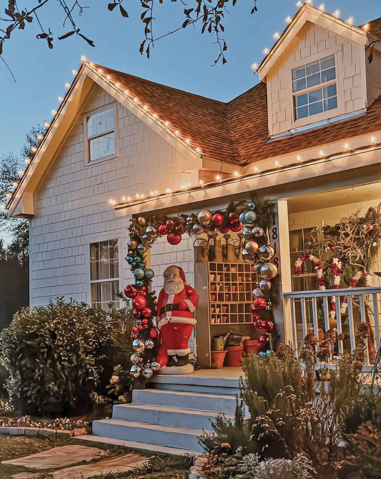 A Large Santa Figure Under a Garland Archway — Christmas House Exterior Decor