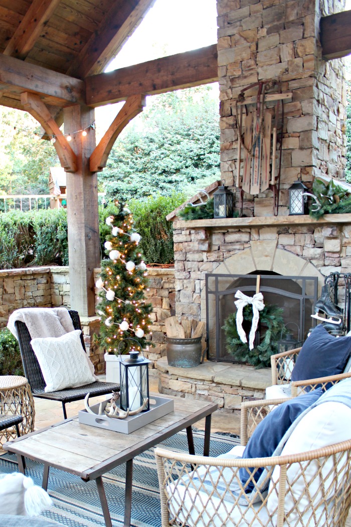 Rustic Lodge Patio with Stone Fireplace and Wicker Seating Rustic Lodge Patio with Stone Fireplace and Wicker Seating — Winter Porch Decor