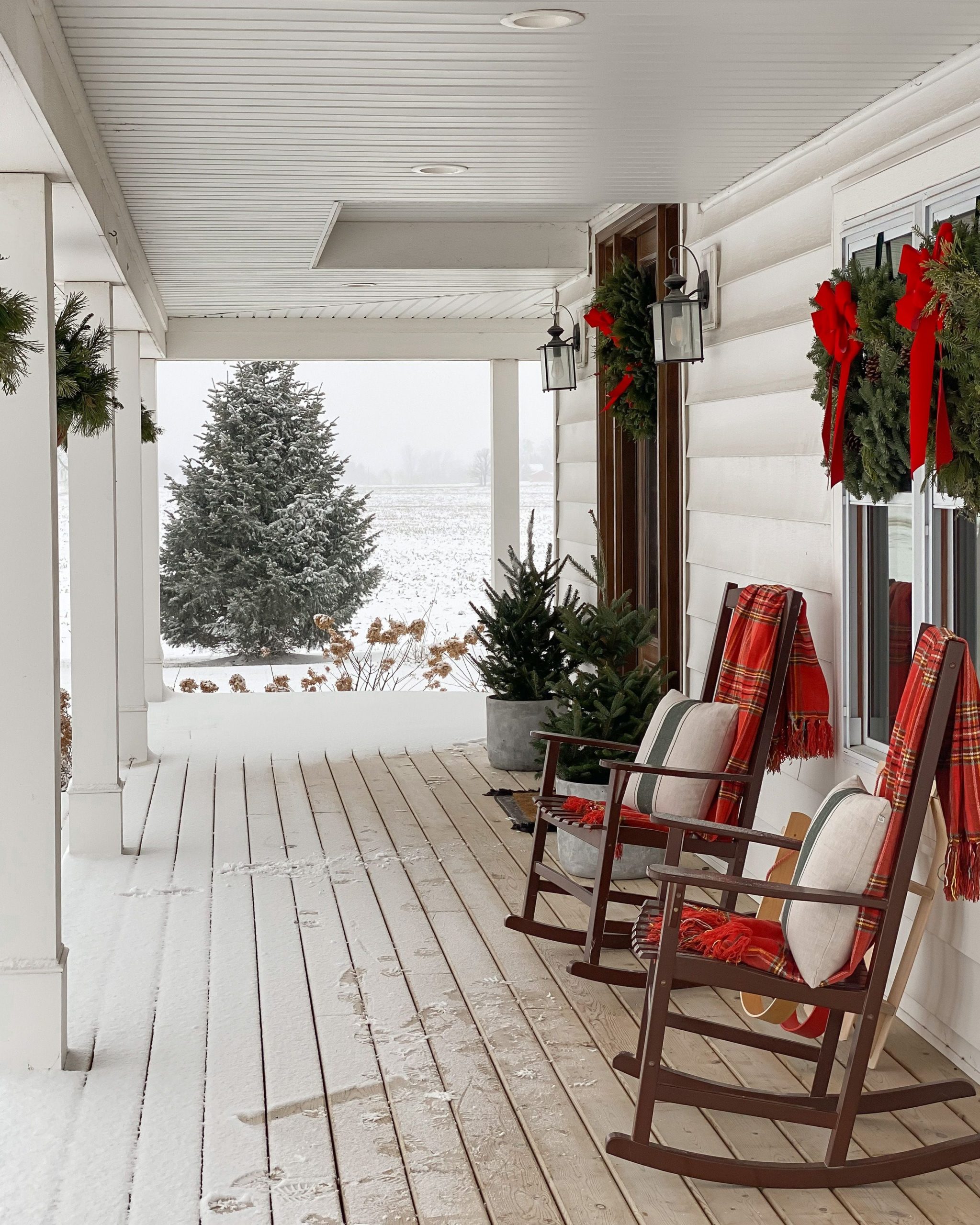 Snow-Covered Farmhouse Porch with Red Plaid Throws on Rocking Chairs Snow-Covered Farmhouse Porch with Red Plaid Throws on Rocking Chairs — Winter Porch Decor