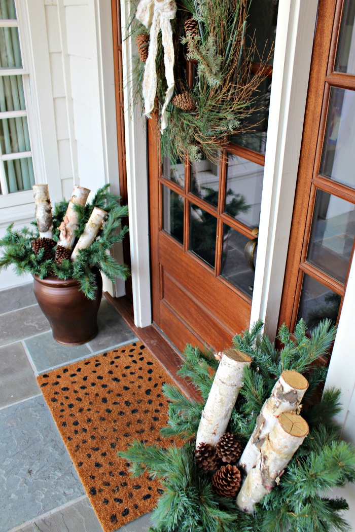 Planters with Pine Branches and Birch Logs Flanking a Wreath Door — Christmas Porch Planters
